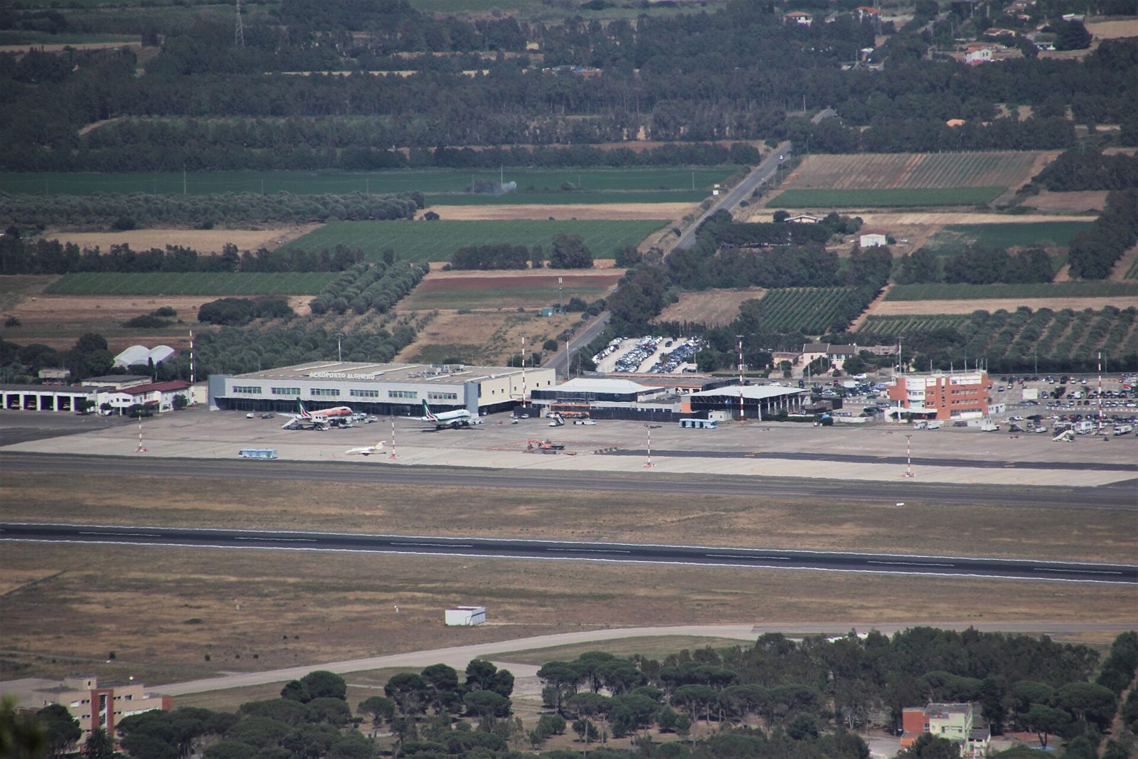 Il terminal dell'aeroporto di Alghero-Fertilia visto dall'alto, tra i campi coltivati della Nurra
