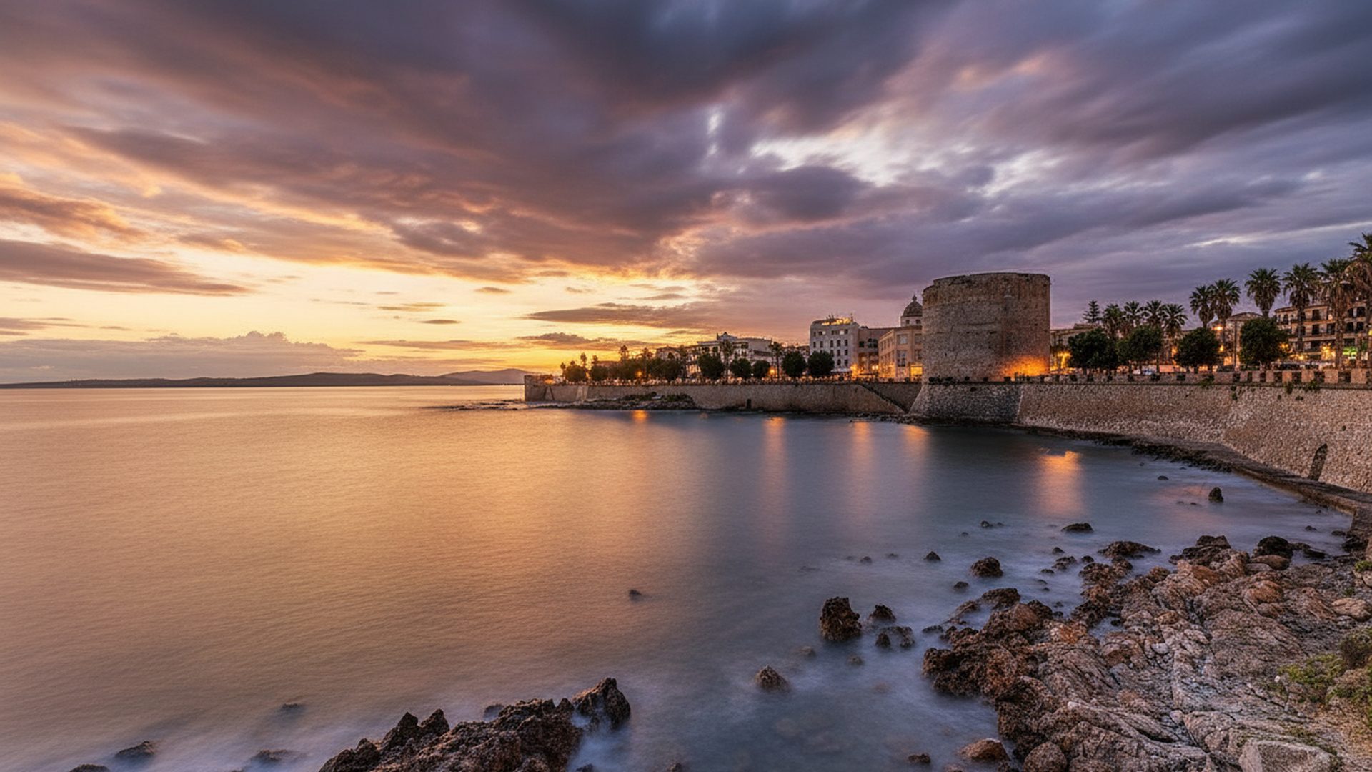 I bastioni di Alghero sul mare al tramonto